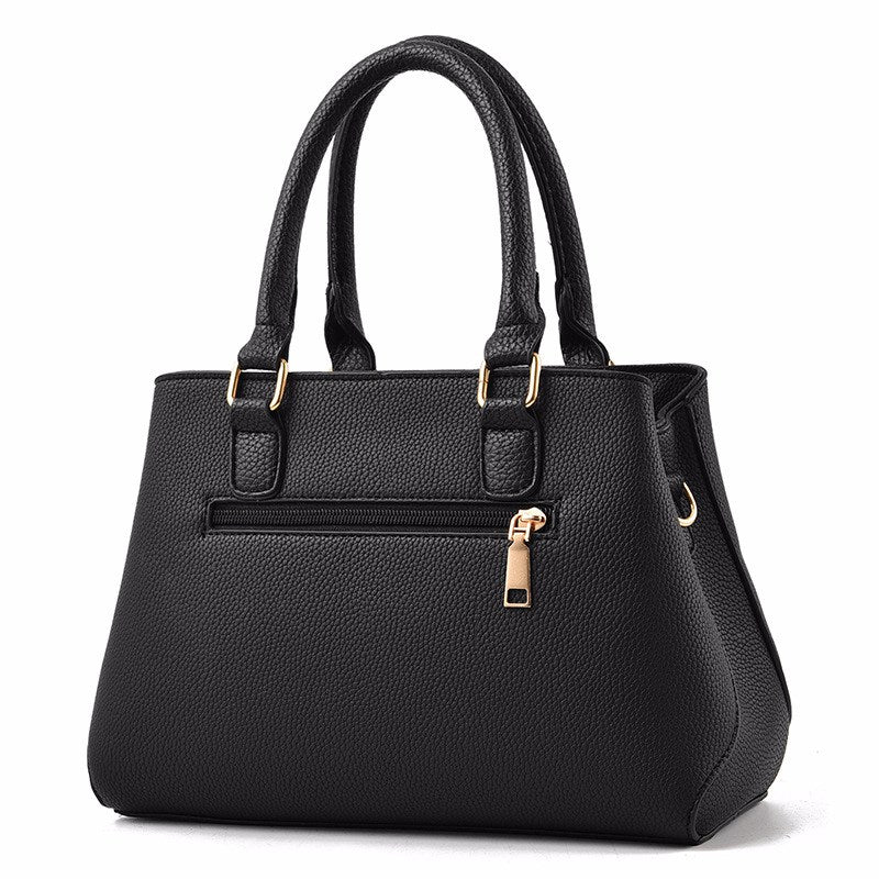 Embossed top handle handbag with pompom