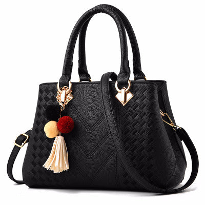 Lottie | Embossed handbag with pompom charm and strap