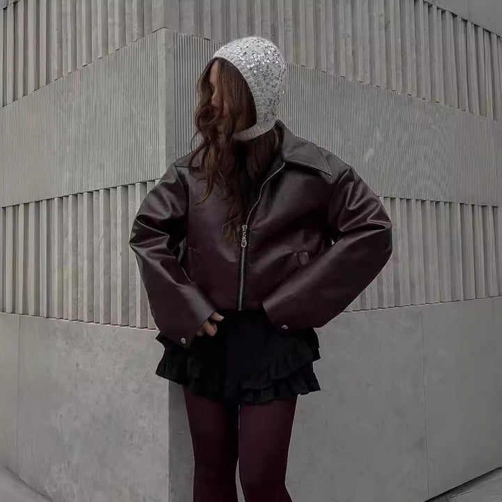 Woman in a cropped burgundy faux leather jacket
