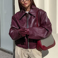 Woman in a cropped burgundy faux leather jacket